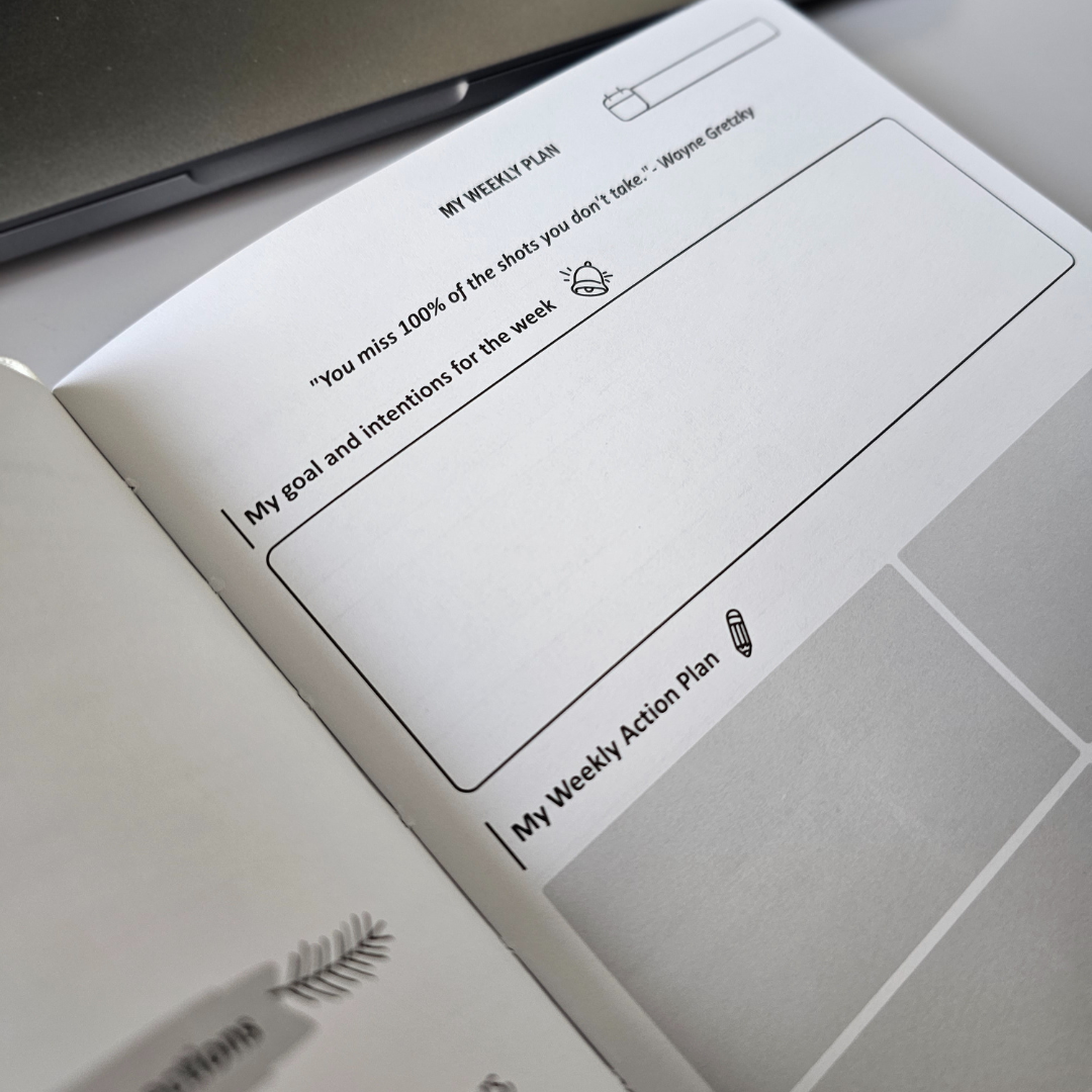 Personne utilisant l'agenda non daté Job Jumps pour organiser ses objectifs de carrière et améliorer son équilibre travail-vie personnelle